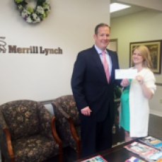 Ryan Kirby of Merrill Lynch presents JAES president Jayme Hayes with a $5,000 check to support JA programs